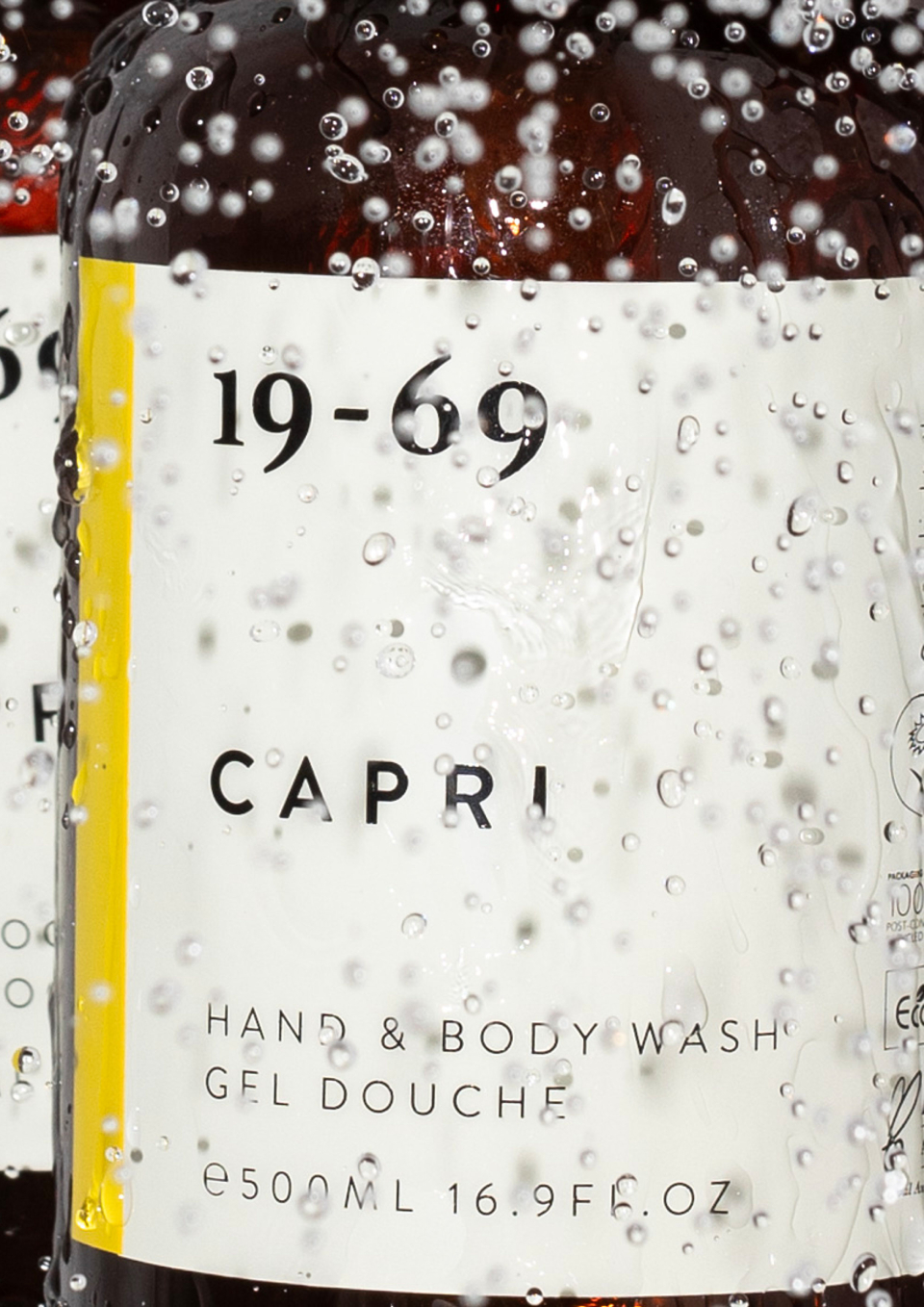 19-69 Capri Hand & Body Wash im Hotelbad mit Wassertropfen auf der Flasche.